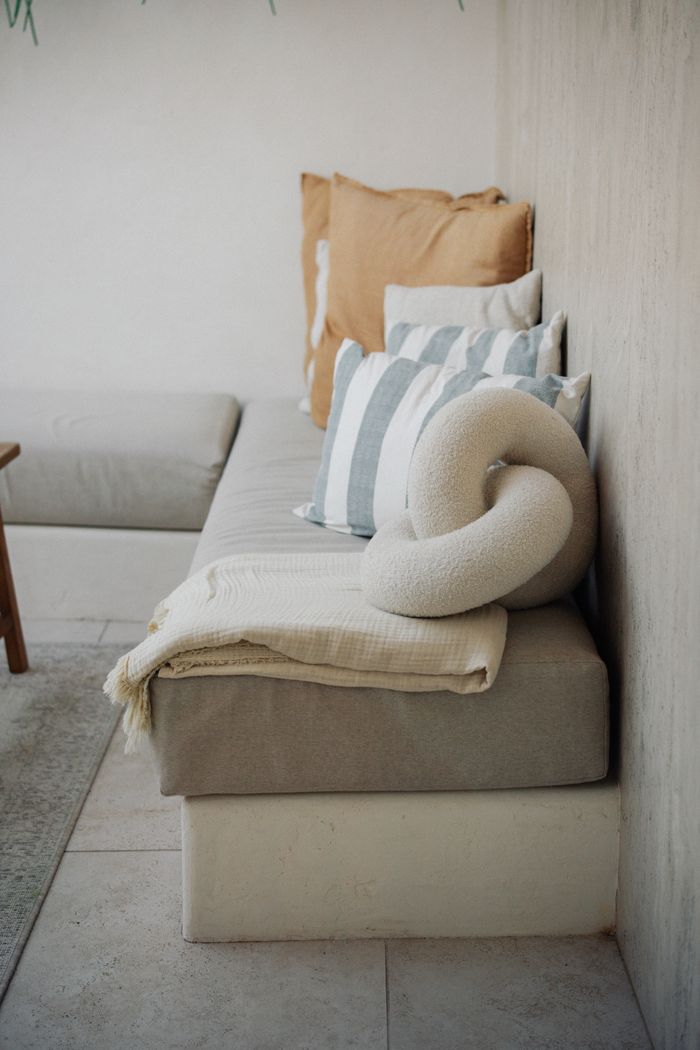 services-02 A cozy and minimalist living room with pillows and a decorative throw.