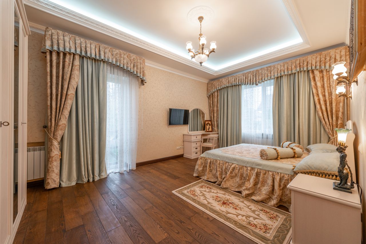 heros-img Luxurious classic bedroom with ornate curtains and furnishings.